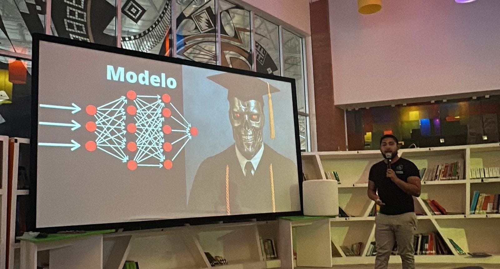 Ramses presentando una charla sobre IA con una slide de red neuronal etiquetada como 'Modelo'.
