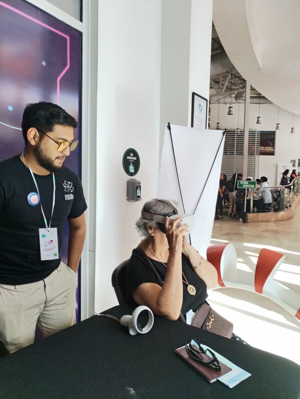 Ramses con camiseta Fisión acompañando a una participante con un visor de realidad virtual en Talentosas.