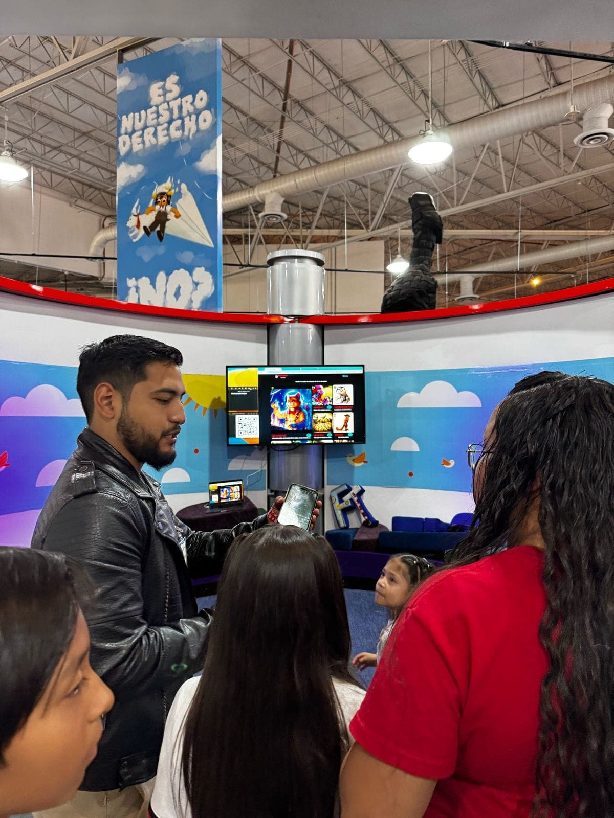 Ramses mostrando contenido a un grupo de niños en la exhibición 'Es Nuestro Derecho'.